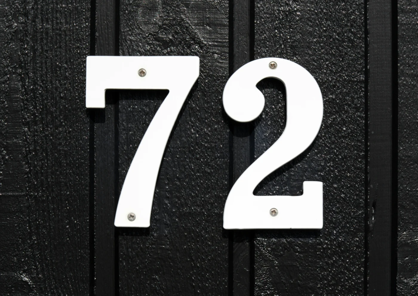 A close-up photo of the number 72 on a door.
